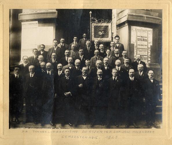 Les membres de la société dramatique De Rozentak avec leur drapeau réunis devant la Maison communale de Molenbeek-Saint-Jean, 1925