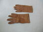 Een paar bruine leren handschoenen, met op de wreef drie naden ter versiering en één  knoop aan de pols, s.d. [1950].<br>