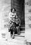 Photo Femme et enfant (mère et fils ?) sur les marches d'un immeuble Rue d'Ostendael, 12 (Molenbeek-Saint-Jean), photogr. anon., s.d. [années 1930].<br>