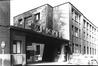Photo Entrée de la manufacture de tabacs Saint-Michel, Rue Gabrielle Petit, 4-22 (Molenbeek-Saint-Jean), photogr. anon., 1975.<br>