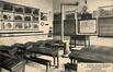 Prentkaart 'Institut Saint-Jean-Baptiste', een klaslokaal, didactische borden en een kolenkachel (Sint-Jans-Molenbeek), uitg. L. Lagaert (Brussel), 1908.<br>