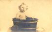 Carte photo Jeune enfant au bain dans une cuve en bois, photogr. Alouvois (Bruxelles), 1928.<br>