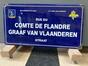 Plaque de rue émaillée Rue du Comte de Flandre / Graaf van Vlaanderen straat (Molenbeek-Saint-Jean), Emaillerie belge (Molenbeek-Saint-Jean), tôle, 1999.<br>